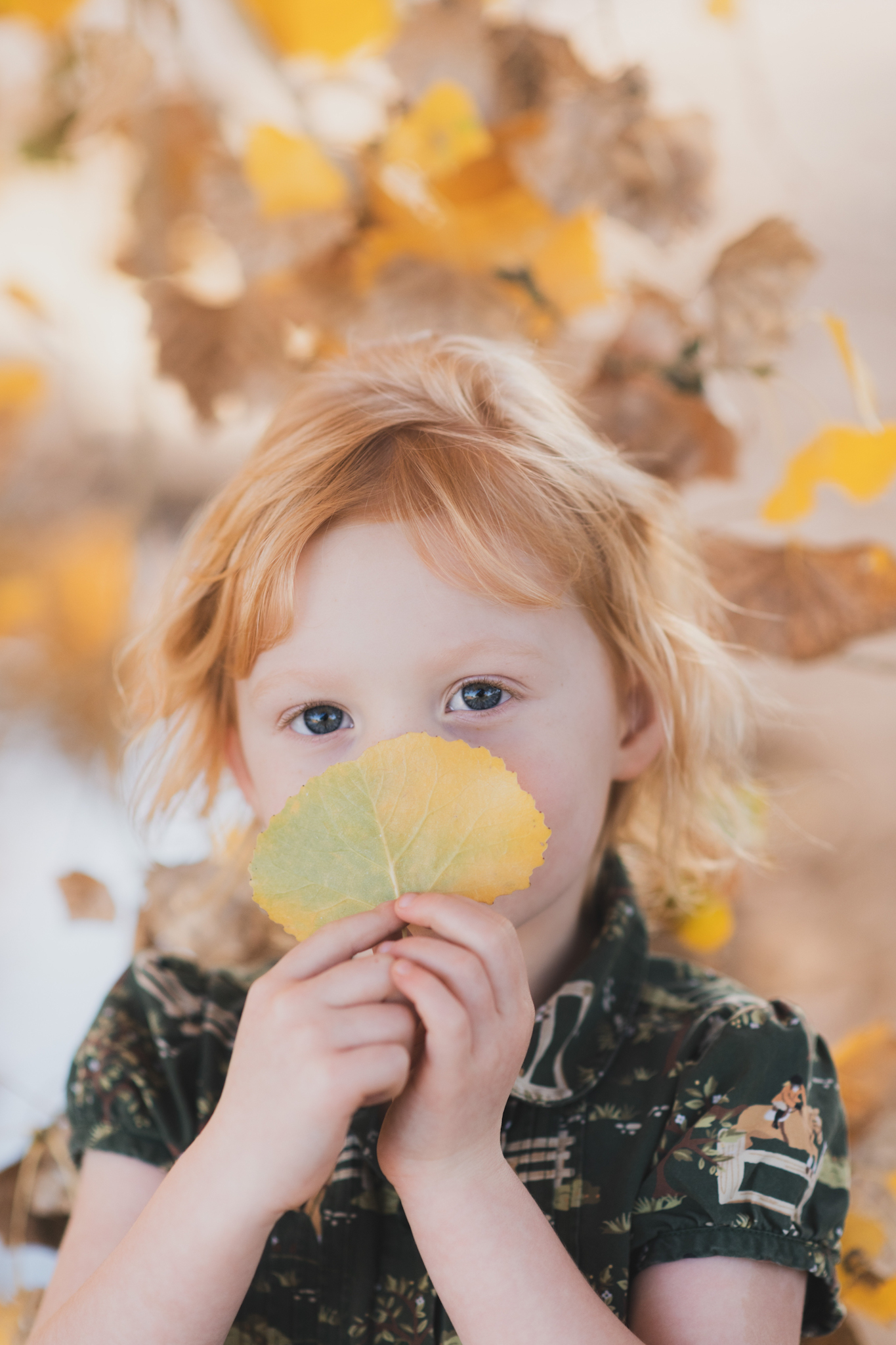 Dark and moody photo shoot of a four year old girl in a pink cowgirl dress at the Hesperia Lakes recreational park in Hesperia California. She is smiling and spinning for the inland empires best childr photographer. Big trees with lots of orange leaves are the backdrop of the lifestyle photoshoot in the high desert