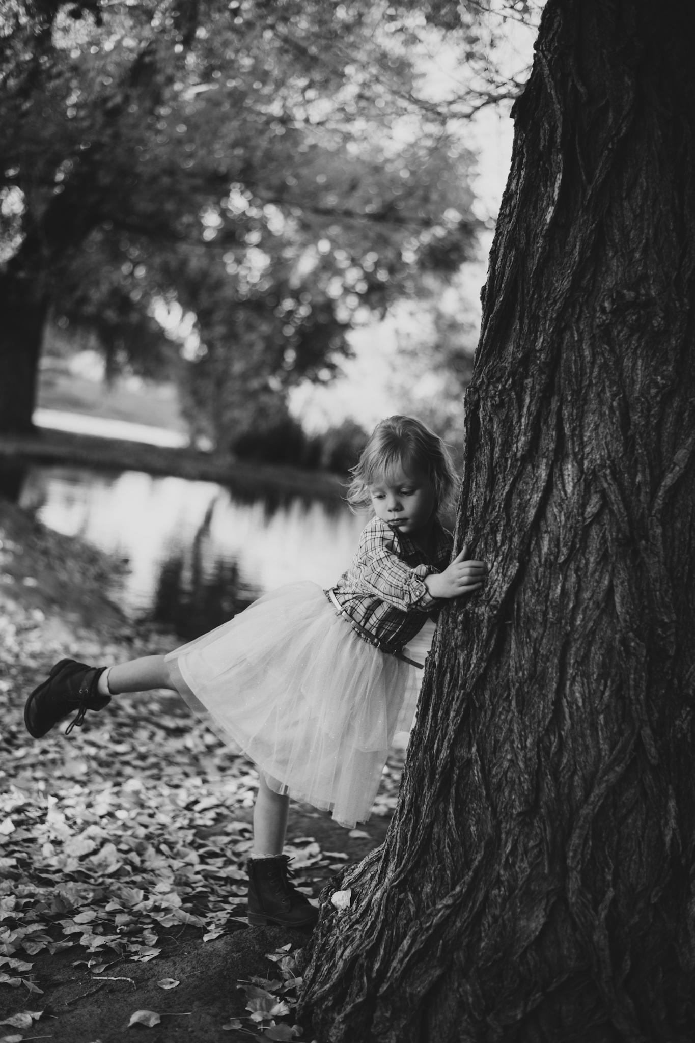 Dark and moody photo shoot of a four year old girl in a pink cowgirl dress at the Hesperia Lakes recreational park in Hesperia California. She is smiling and spinning for the inland empires best childr photographer. Big trees with lots of orange leaves are the backdrop of the lifestyle photoshoot in the high desert