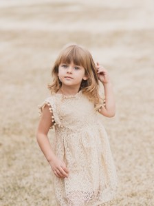Light and airy portrait of a family posing for the high deserts best photographer at the Mojave narrows national park in Victorville California. They are dressed in formal clothing in front of giant water towers and smiling for the camera
