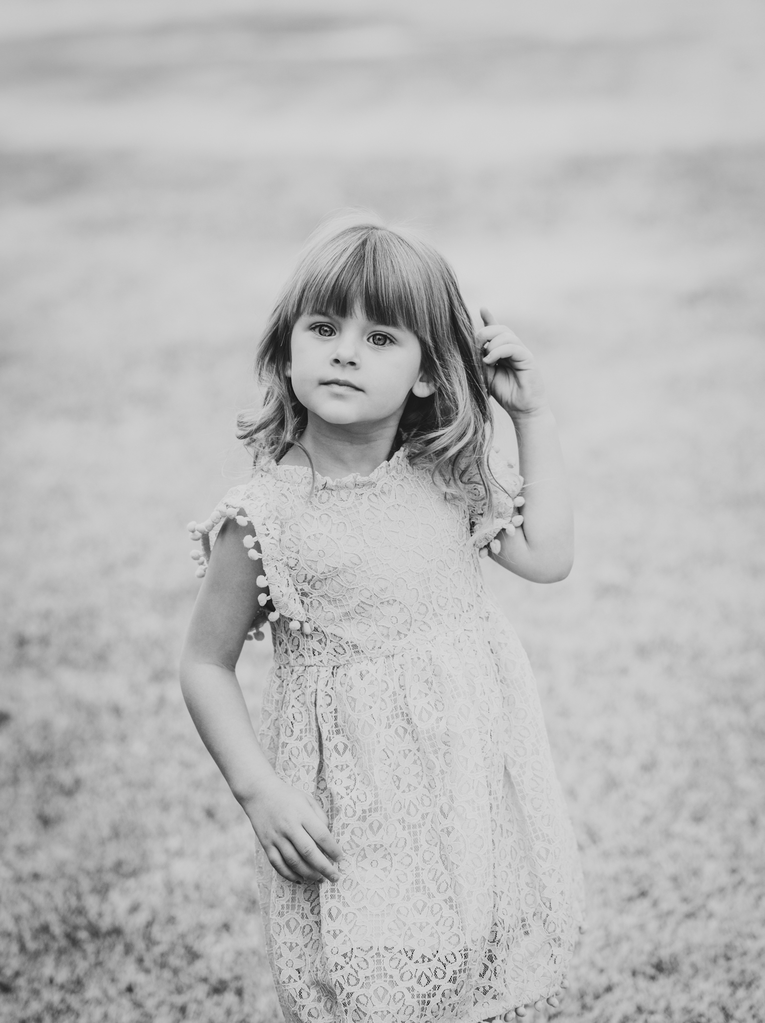 Light and airy portrait of a family posing for the high deserts best photographer at the Mojave narrows national park in Victorville California. They are dressed in formal clothing in front of giant water towers and smiling for the camera