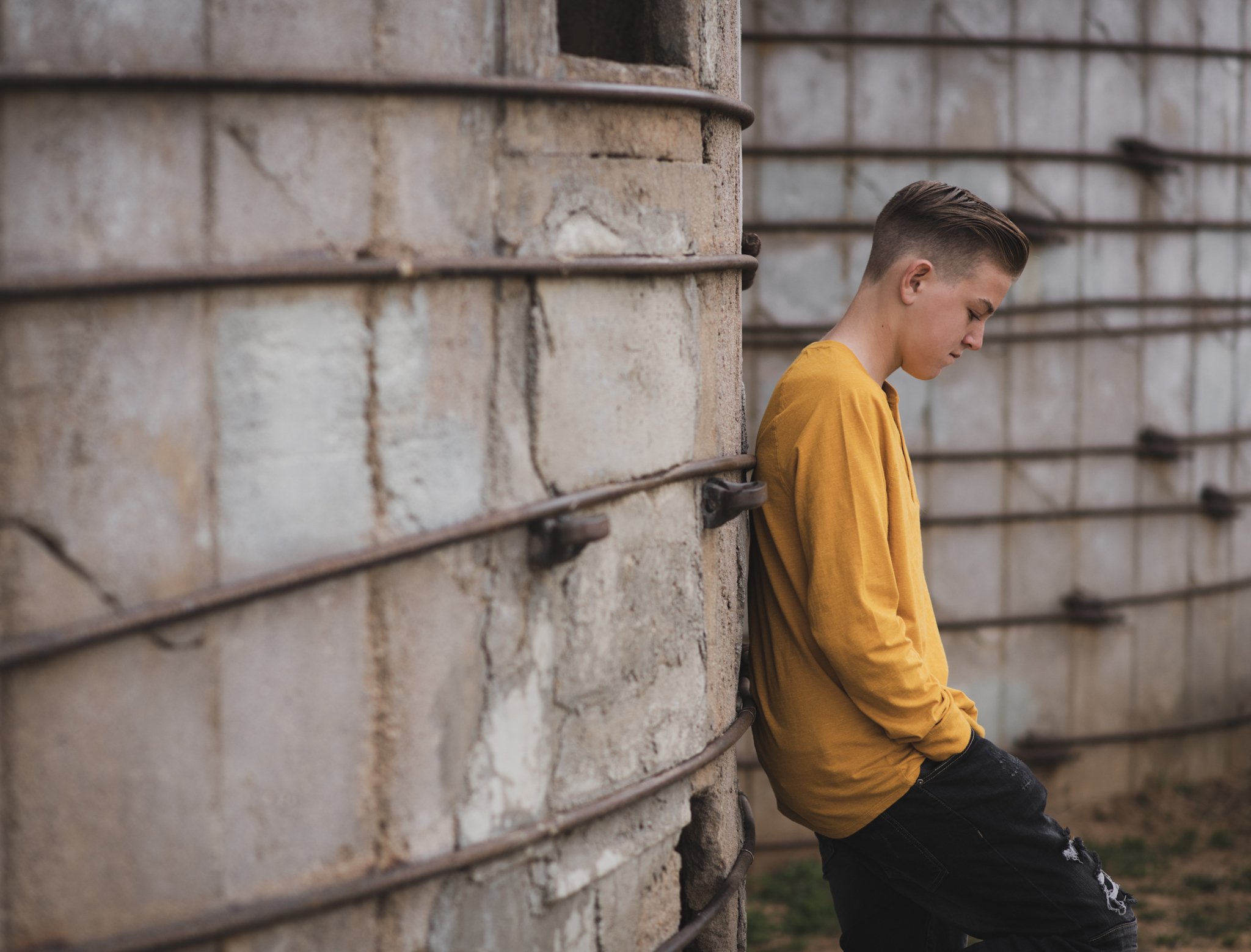 Light and airy portrait of a family posing for the high deserts best photographer at the Mojave narrows national park in Victorville California. They are dressed in formal clothing in front of giant water towers and smiling for the camera