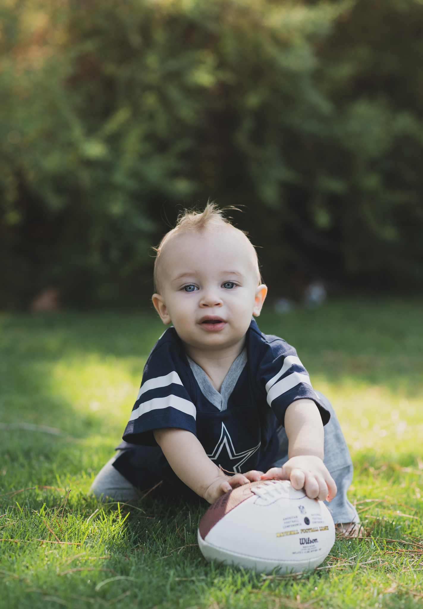 Light and airy portrait of a baby’s first birthday cake smash photoshoot shot in lake los angeles california in los angeles county. baby boy is smashing cake between his fingers and smiling at the camera of the high deserts best family photographer