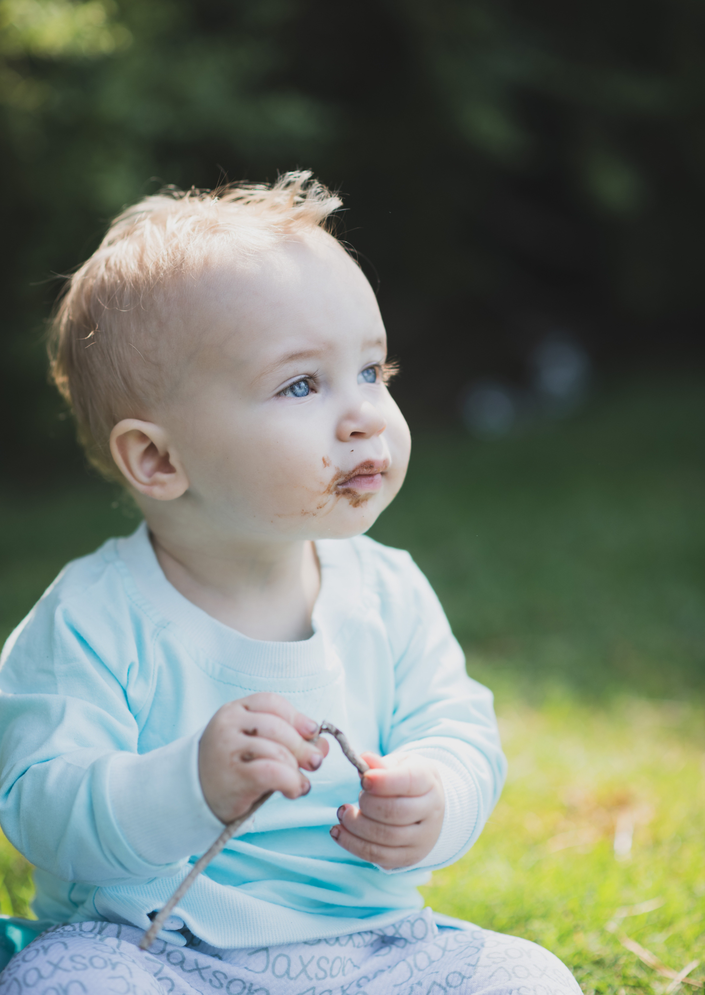 Light and airy portrait of a baby’s first birthday cake smash photoshoot shot in lake los angeles california in los angeles county. baby boy is smashing cake between his fingers and smiling at the camera of the high deserts best family photographer