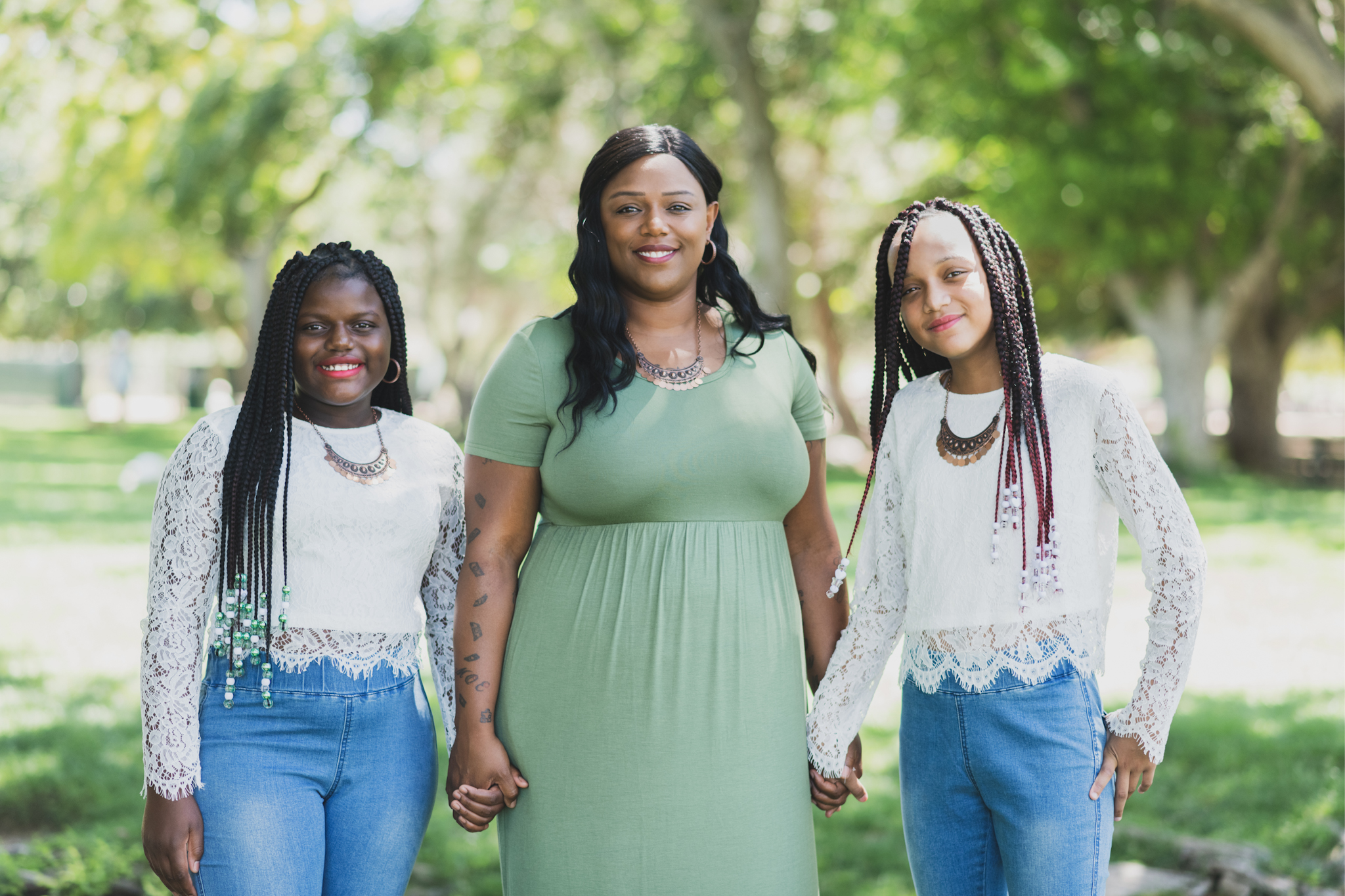Light and airy family photoshoot at Hesperia Lake Park in the Inland empire. A Large family smiles and laughs for the high deserts best photographer. The scenery is green with lots of beautiful trees and nature. There is a pond in the background of these family portraits in the inland empire