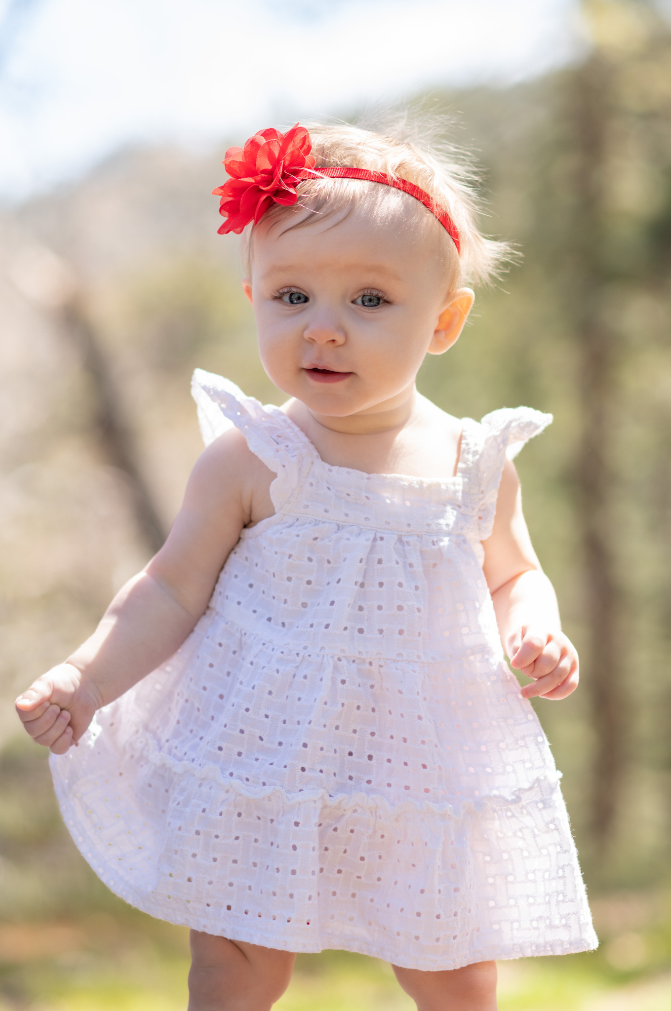 Light and airy pictures of a baby girl sitting on a magical bridge in the mountains of Wrightwood California. Baby is smashing a colorful cake and smearing it on her face in these high desert portraits
