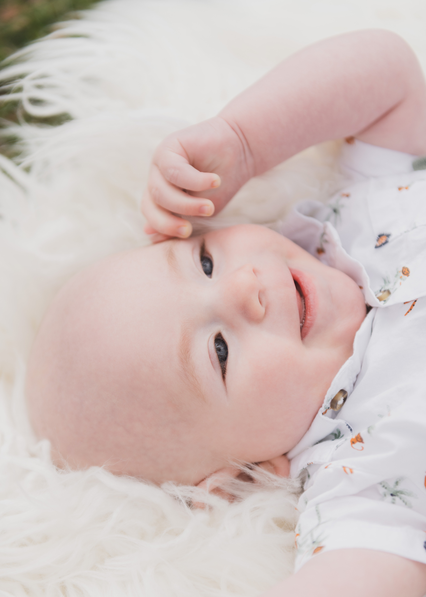 Light and airy pictures of a couple with a baby boy. Couple is wearing blue holding baby boy and smiling in these high desert portraits shot in the beautiful Hesperia Lakes park in the inland empire. There is a tree with white flowers blooming in the background