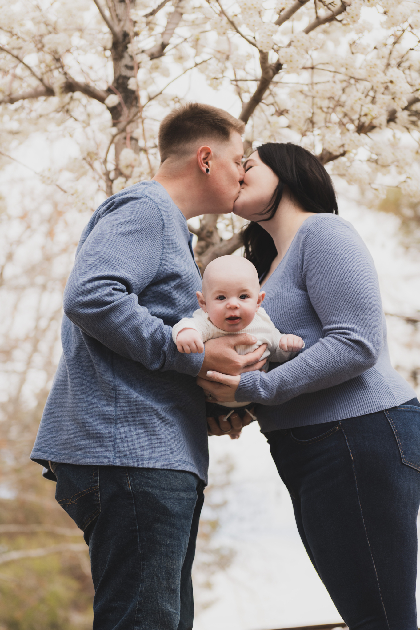 Light and airy pictures of a couple with a baby boy. Couple is wearing blue holding baby boy and smiling in these high desert portraits shot in the beautiful Hesperia Lakes park in the inland empire