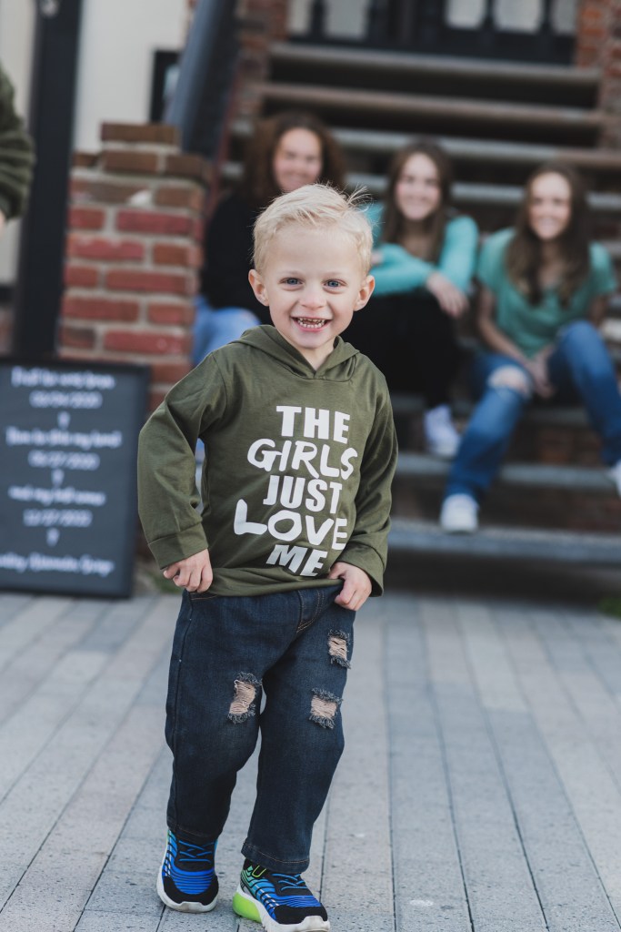 Light and airy shoot of a family at the beach. A little blonde boy named Bradley got adopted and they are celebrating. He now has two older sisters who hold his hands in the water and a beautiful mother with dark hair that plays with him in the waves. He is loved
